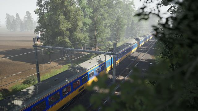 ICM train driving along a tree lined railway, a stork perched on one of the gantries