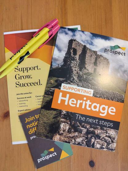 3 leafllets for the Prospect union stacked diagonally over each other with 2 pens in the top left corner. The bottom-most leaflet says "Join today, notice the difference". The right-most says "Supporting Heritage" and the left-most says "Support.Grow. Succeed."