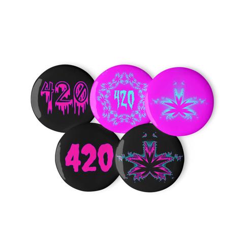 A set of 5 stoner pin buttons.
1. A black pin with the number 420 in neon pink dripping horror style font with a blue outline.
2. A pink pin with the number 420 in light blue creepy font surrounded by some kaleidoscope cannabis leaf art.
3. A pink pin with blue and pink pot leaf art.
4. A black pin with the number 420 in neon pink creepy font with a blue outline.
5. A black pin with hot pink, black, and blue weed leaf art.
The background of the photo is white.