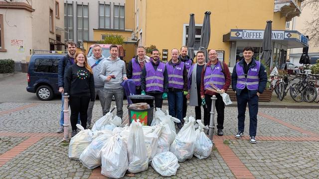 Eine Gruppe von Voltas steht hinter einem Haufen gefüllter Müllsäcke. Sie wirken erleichtert und auch stolz auf das Ergebnis.