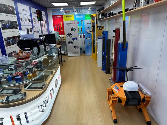 Blick in ein kleines Geschäft in dem mehrere Säulen für Schranken stehen und mehrere Roboter Hunde