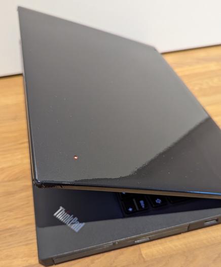 Der Deckel des ThinkPad T440p nachdem die Autofolie aufgebracht wurde.
Man sieht weder das ThinkPad- noch das Lenovo-Logo. Nur der ThinkPad i-Punkt wurde ausgeschnitten und leuchtet.
Leider ist die Folie nicht perfekt glatt an der Ecke.
