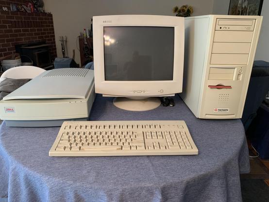 A PowerComputing PowerTower Pro 225 on my table, along with the HP monitor, third party keyboard, and UMAX flat bed scanner