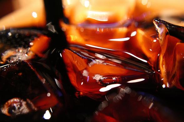 Una foto macro de hielos frotando en refresco de cola