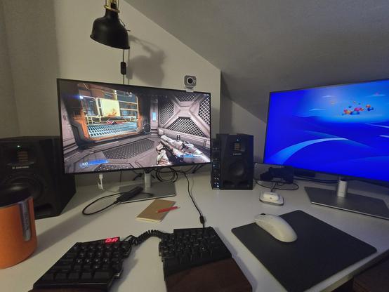 Dual screen with doom running on the left and an empty screen on the right. Some desk items are also visible: keyboard, mouse, coffee, and some notes.