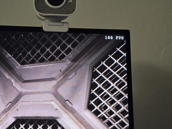 Closeup on the screen showing the FPS counter. The number changes rapidly and is somewhat blurry. It looks like about 150FPS were measured at the time of thr photograph.