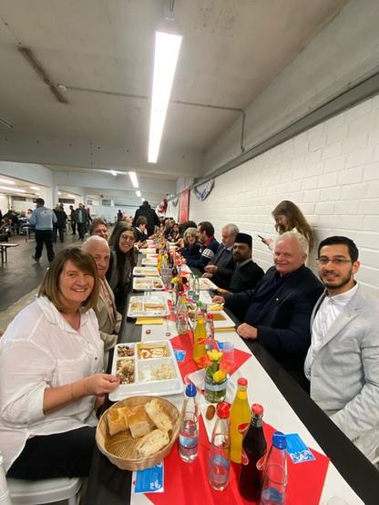 Lange Tafel mit Gemeinderät*innen sowie Mitgliedern des Rats der Religionen