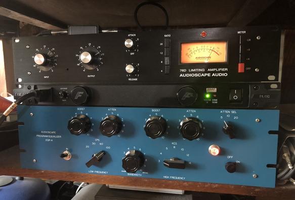 A color photo of three rackmount music hardware gear. Top, the Audioscape 76D Limiting Amplifier. Middle, a Furman PL-8C power conditioner. Bottom, the Audioscape EQP-A Pultec-style EQ. The 76D has an old school lighted meter with needle pointing to roughtly 1 o'clock. The Furman has a light indicating it's on, and the EQP has a similar light. The 76D is black with silver dials, the Furman is also black and the EQP-A is in classic Pultec blue with large black knobs.