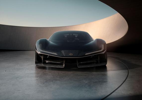 Sleek black sports car with sharp headlights in a modern, curved concrete setting under a clear sky.