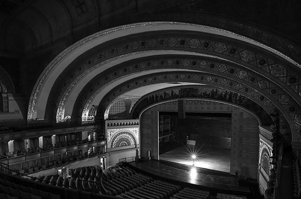 Depiction of a ghost light onstage of an empty theatre. Black and white photo by The Michigan Daily.