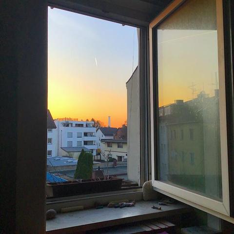 Foto mit Blick aus Molos Arbeitszimmer.
Sonnenaufgang über Ffm. Über den Dächern der Nachbarschaft in der Bildmitte der Schornstein des Heizkraftwerks.