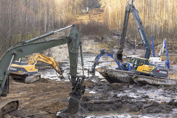 Photo of a large bog with multiple heavy equipment (excavators, pumps) working in it