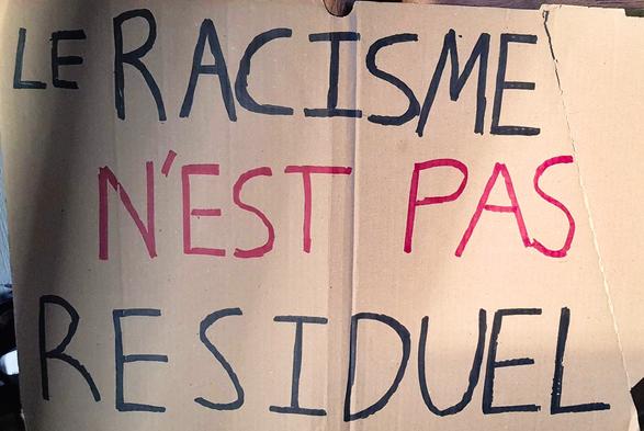 Pancarte avec écrit "Le Racisme n'est pas résiduel".