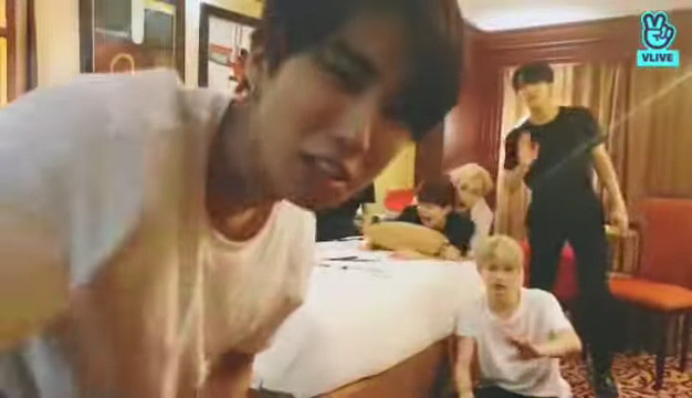 skz in a hotel room. Han's up close to the camera and about to turn it off. Seungmin's still bent over the edge of the bed and Chan has aggressively pounced on him, has his arms pinned, and is shaking him around. Changbin and Felix are awkwardly waving at the camera.