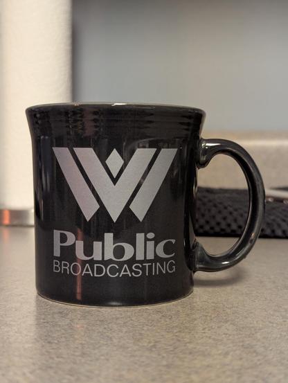 A dark grey mug with the West Virginia Public Broadcasting logo on it.