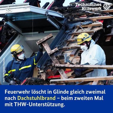 Zwei Menschen arbeiten an einem ausgebrannten Dach und entfernen Teile der Holzkonstruktion des Dachbalkens.