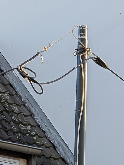 Pole with some overhead electrical wires, barely held up by some Wago connectors.
