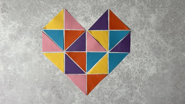 A mosaic paper heart made up entirely of different coloured triangles.