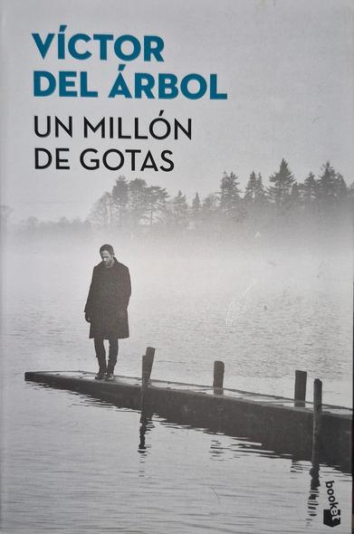 Fotografía de la portada del libro: Un millón de gotas de Víctor del Árbol. En ella se ve al fondo mucho árboles entre la bruma y más cerca se ve a un hombre de pie encima de un embarcadero de madera en lo que parece ser un lago. Todo en tonalidades grises.