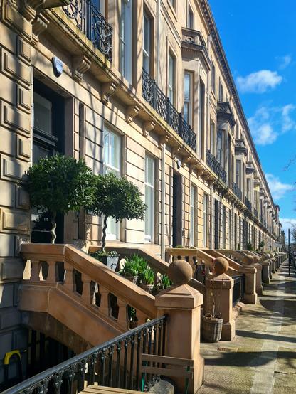 Looking along a terrace of Classical townhouses with renaissance style detailing.