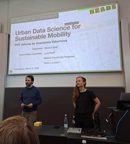 Male and female researchers in front of title slide