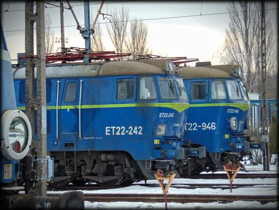 Niebieskie lokomotywy towarowe PKP Cargo, ustawione w perspektwie od lewej strony kadru na tle zimowegockrajobrazu. Jedna częściowo przysłania kolejną, licząc od krawędzi zdjęcia. Ze skrajnej lokomotywy widać tylko reflektor.