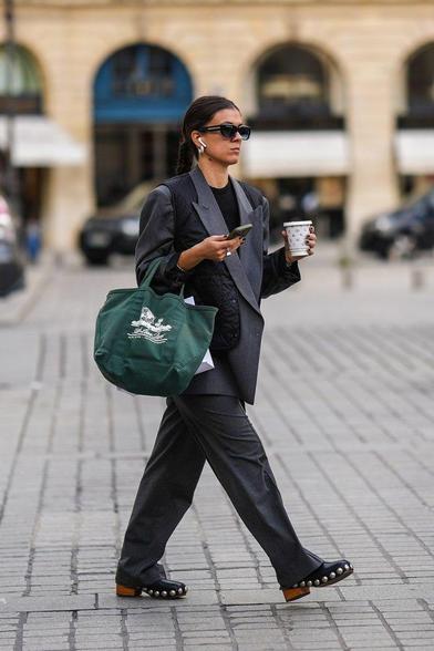 Business woman walking down the street while drinking her morning coffee