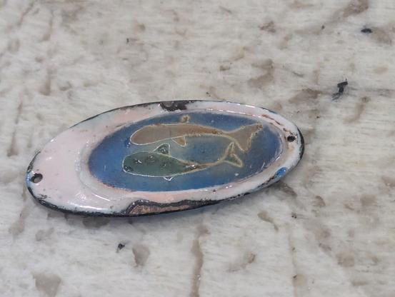 Back side of plique-à-jour pendant of 2 fish
