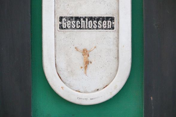 a closed window, a figure of Jesus on the cross