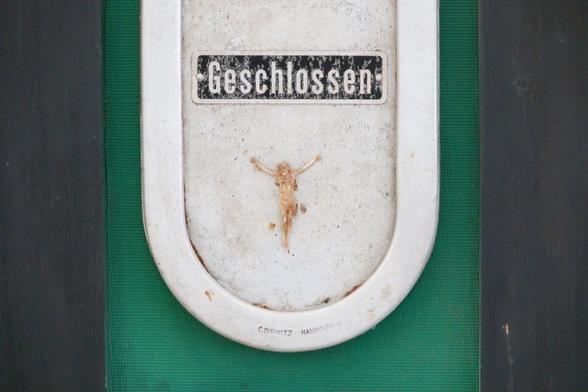 a closed window, a figure of Jesus on the cross