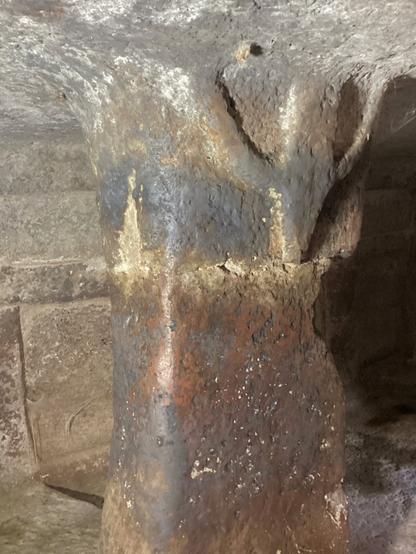 This tomb preserves peculiar architectural and decorative elements, like a bull's head relief on a pillar  (or some say upside-down anthropomorphic figure)