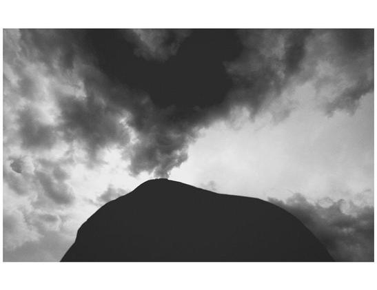bw photo of a mountain shape and clouds