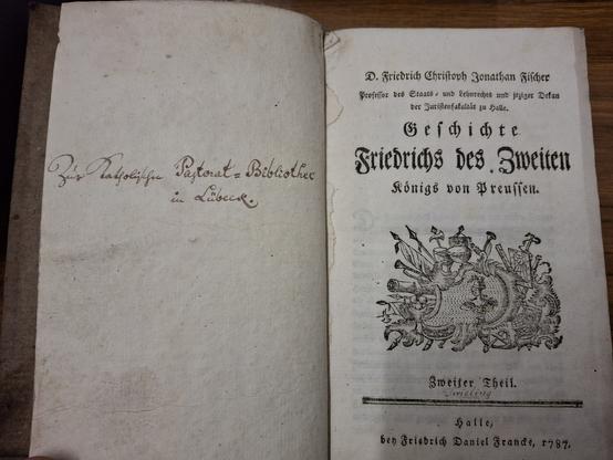 Links die Titelseite eines historiographischen Buches über Friedrich des Zweiten. Autor ist ein Friedrich Christoph Jonathan Fischer. Unter dem Titel ist ein großes Wappen. Darunter steht handschriftlich der Name Twieling. Veröffentlichungsjahr 1787. Veröffentlichtungsort: Halle.
Rechts eine leere Seite mit dem handschriftlichen Eintrag: Zur Katholischen Pastoral-Bibliothek in Lübeck.