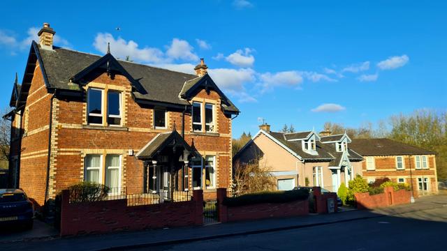 A row of polychromatic brick buildings on Kelvindale Road in Glasgow.