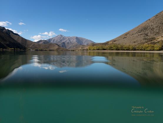 lake surrounded by mountains viewed partially from underwater.