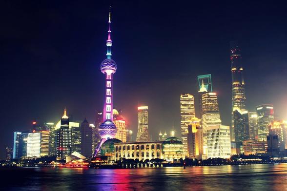 La mégapole chinoise qu'est Shanghai se pare de ses plus beaux atouts la nuit. Les lumières des gratte-ciels se reflètent sur le Huangpu. Une palette de couleurs du bleu au jaune, en passant par le mauve/rose, dépeint un tableau tel Mondriant.