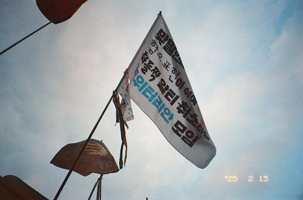 “맞말인데 혐오 표현이 섞여 화들짝 알티 취소하는 트위터리안 모임” 깃발이 휘날리고 있다. 같은 깃대 아래쪽에는 “차별금지법 있는 나라” 깃발과 무지개 머리띠가 함께 휘날리고 있다.