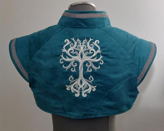 Boléro medfan couleur bleu/vert canard avec des galons argentés et une broderie dans le dos représentant un arbre de vie entrelacé. Vue de dos.