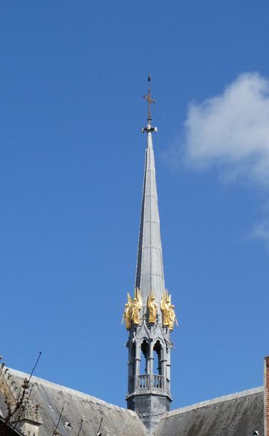 the skinny spire of Basilique Saint-Nicolas at Nantes, with trumpeting gold-leafed angels, France. March 2025.