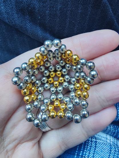 The first half of the buckyball: six pentagons made of golden spheres, and ten hexagons made of silvery ones, arranged in something like a hemisphere.