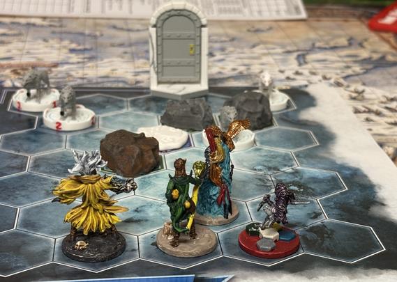 Four minis on a Frosthaven battle map; facing them are four wolves on numbered bases, some rocks, some difficult terrain, and a metal door in a marble frame leading to the next map.