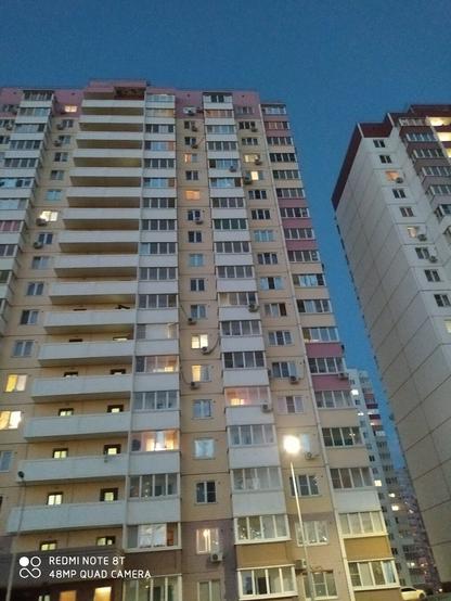 Фото многоэтажки на фоне ночного неба. Сделано снизу вверх