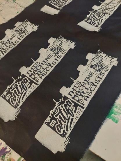 The profile of a synthesizer box with an 'antifa' sticker, and the text 'This Machine Kills Fascists'.