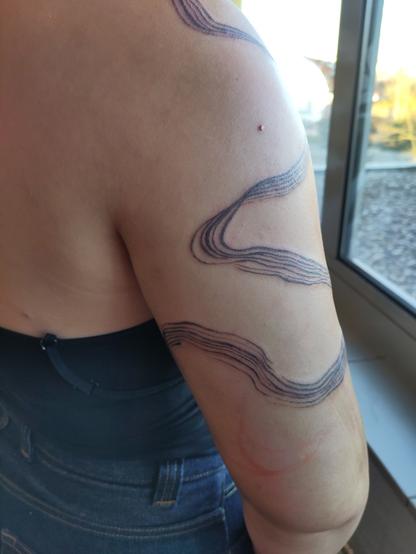 Brushstroke tattoo on an arm