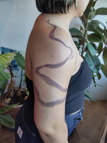 brushstroke tattoo on an arm and shoulder