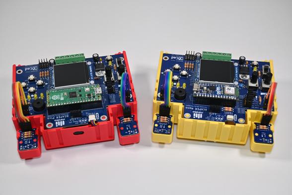 A BEAPER Pico circuit (left) controlled by a Raspberry Pi Pico microcontroller and mounted in a red 3D-printed BEAPER Bot chassis, beside a BEAPER Nano circuit (right) controlled by an Arduino Nano ESP32 microcontroller and mounted in a yellow 3D-printed BEAPER Bot chassis.