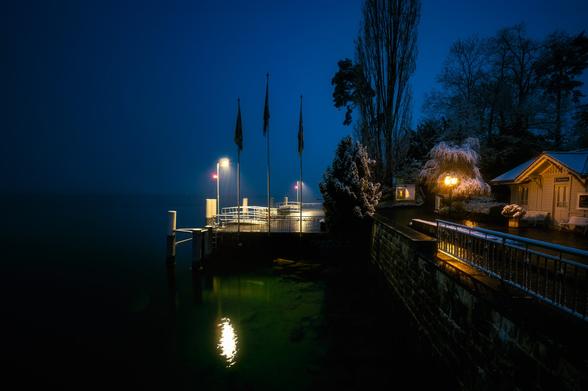 Schiffanlegestelle in der Abenddämmerung mit Neuschnee.