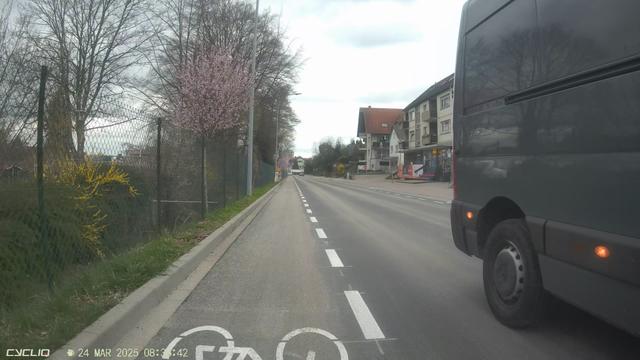 Blick einer Dashcam nach hinten. Ein Transporter überholt trotz oder gerade wegen des Radfahrschutzstreifens viel zu knapp.