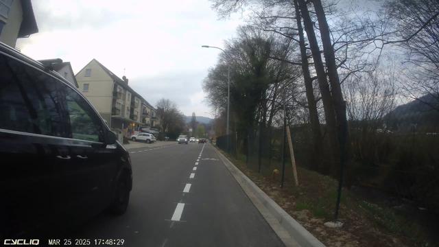 Blick einer Dashcam nach vorne. Ein PKW überholt trotz oder gerade wegen des Radfahrschutzstreifens viel zu knapp.