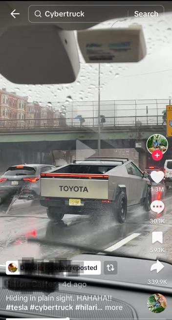A Tesla with a large letters spelling TOYOTA in the back of the car